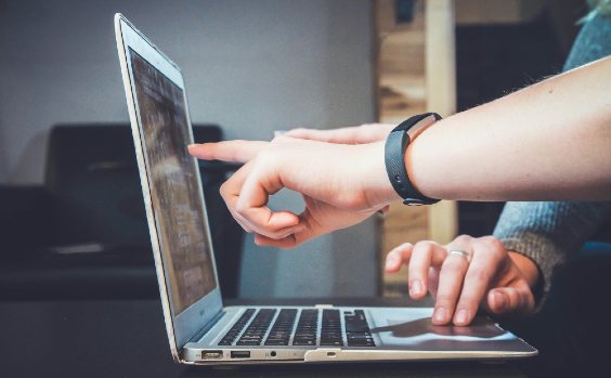 Finger zeigen auf Laptop